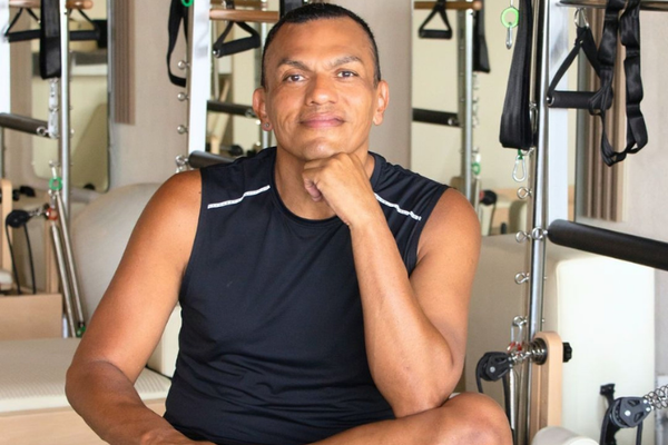 Ricardo Galván, guía de movimiento con más de 30 años de experiencia en Pilates, Yoga y Gyrokinesis a nivel internacional, posando en una postura relajada que refleja equilibrio y consciencia corporal
